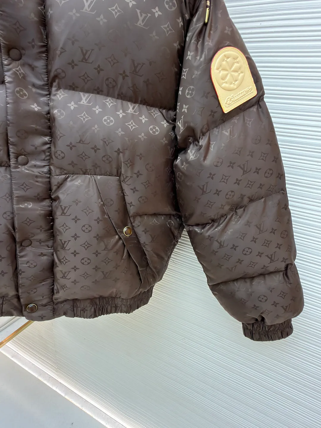 LOUIS VUITTON SKI ski series printed down jacket ●Original version: 35000 purchased and developed ●Item number: 1682303-C75 ●Fabric: white goose down fabric ●Technology: mechanical down filling ●Color: brown ●Version: fitted version ●Weight: about 1750 grams ●Size: 48-50-52-54 ●Description: This LV dark pattern down jacket is made of customized jacquard fabric technology: the body is made of high-gloss nylon material, and the whole body is embossed with Monogram dark pattern. The seamless fusion of pattern and fabric is achieved through fine heat pressing technology, which has both texture and recognition. It adopts zoned down-filling quilting technology, and divides the down-filling areas according to ergonomics to ensure warmth. At the same time, it avoids bloat; the hooded design is equipped with an adjustable drawstring (with leather trim), and the double-button closure on the collar enhances windproofness. The pockets are three-dimensional patch pockets + hidden snap button structure. The cuffs and hem are edged with elastic ribs. The metal snap buttons in the details echo the brand logo. The overall body is adapted to a variety of body shapes through 3D three-dimensional tailoring, taking into account functionality and luxury. The overall wiring is straight and delicate, the fabric is comfortable and soft, and the color is consistent without color difference. It can be matched with the same style to create a fashionable look and control various occasions. Customized accessories, complete with three standards, same style for men and women!